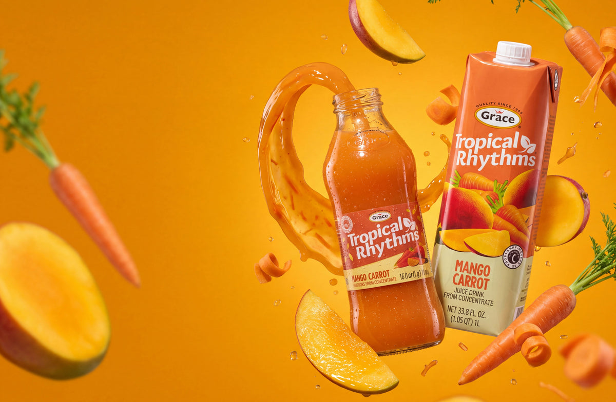 Tropical Rhythms Mango Carrot juice bottles surrounded by splashing juice, mangoes, and carrots on an orange background