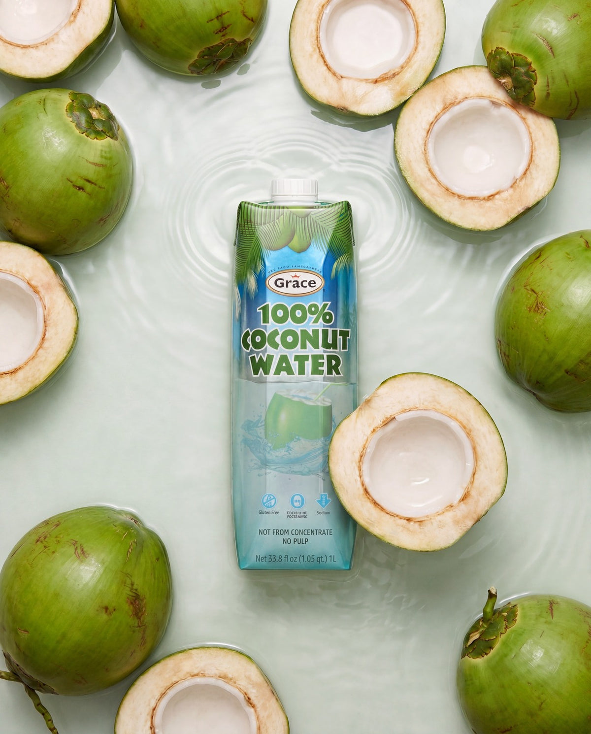 Front view of Grace Coconut Water 1 L container with coconut water label, surrounded by green coconuts in water