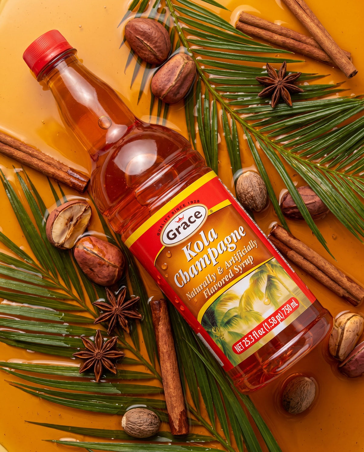 Angled view of Grace Kola Champagne Syrup bottle showcasing its red-and-yellow label on an orange background with spices