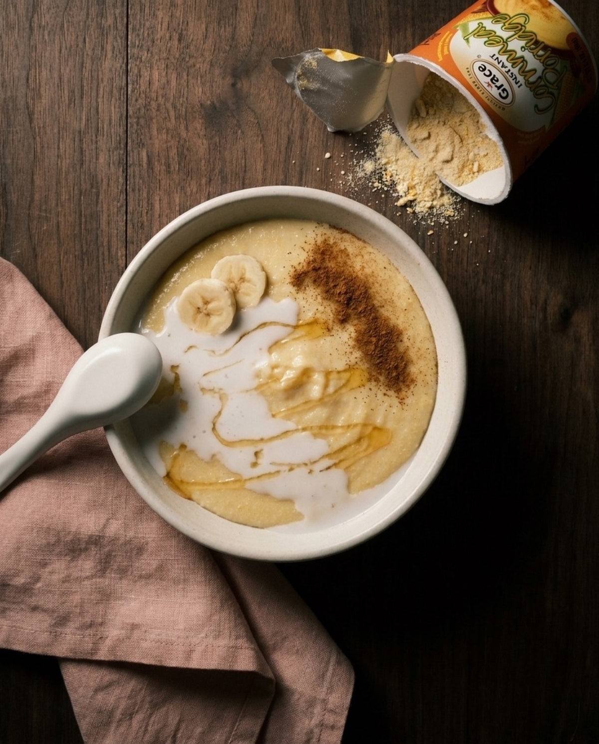 Grace Instant Cornmeal Porridge served in a bowl with banana, honey, and cinnamon beside an open package
