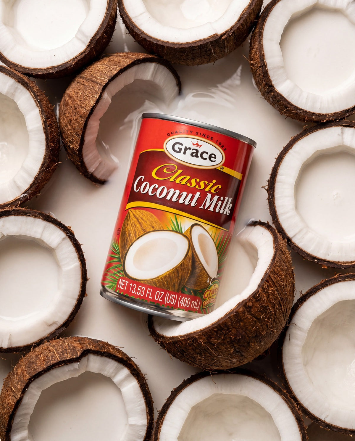 Angled view of Grace Classic Coconut Milk can showcasing red packaging with coconut halves on a white background