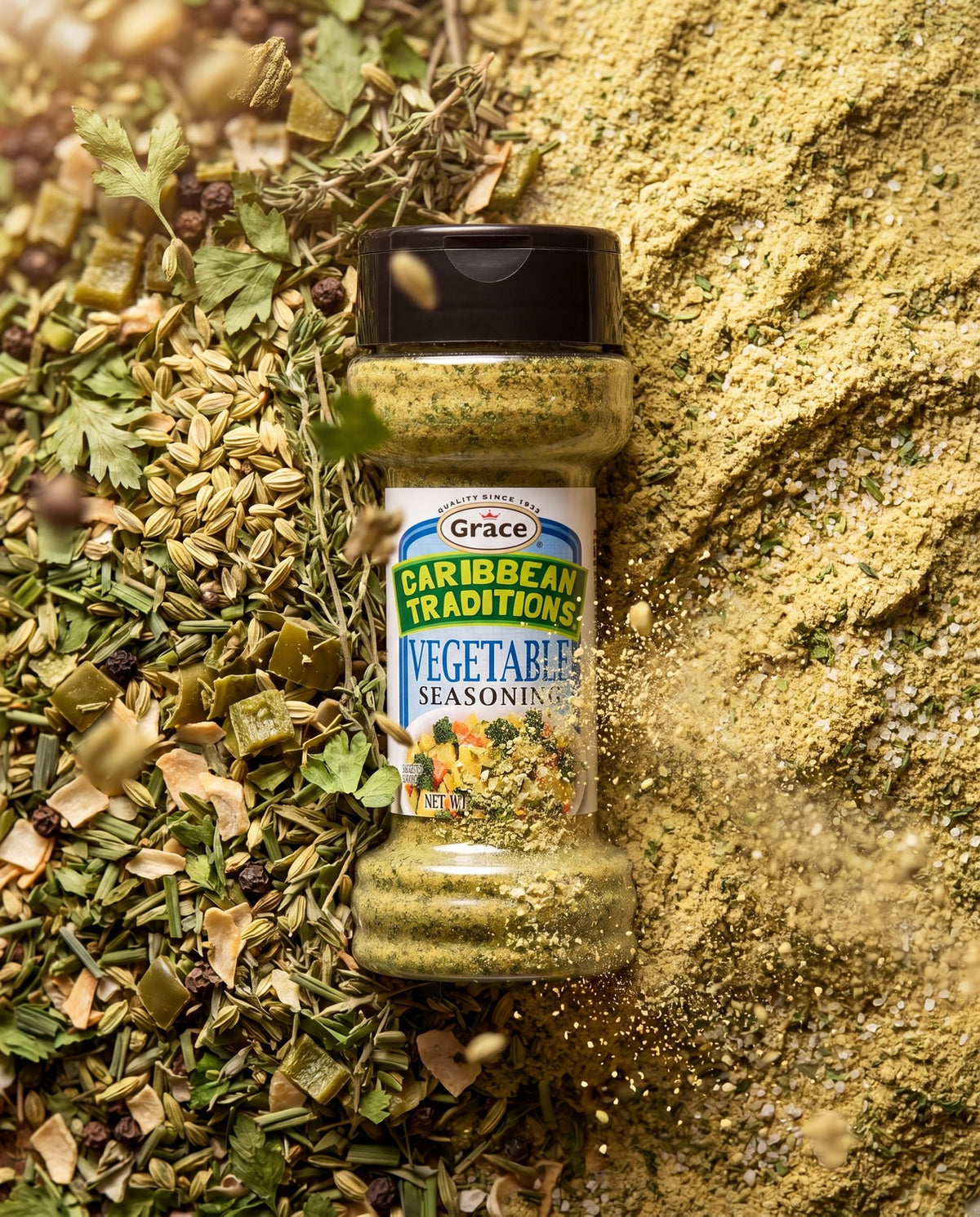 Front view of Grace Caribbean Traditions Vegetable Seasoning showcasing its labeled jar with herbs and ground seasoning background