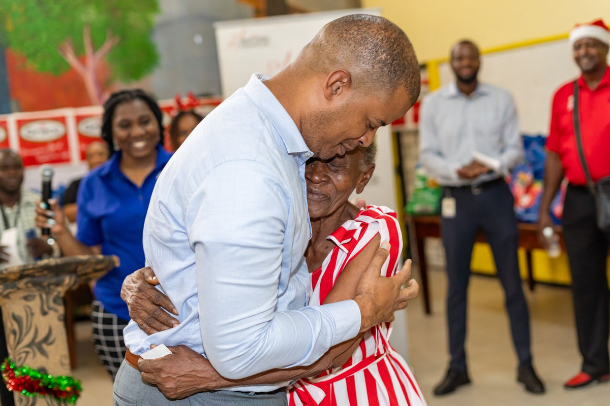 Grace Foods staff member embracing an older woman at a Christmas outreach event